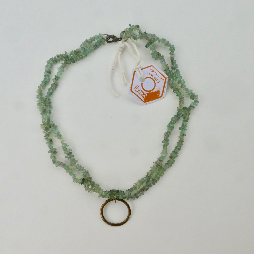 Collar de piedras verdes con círculo de latón